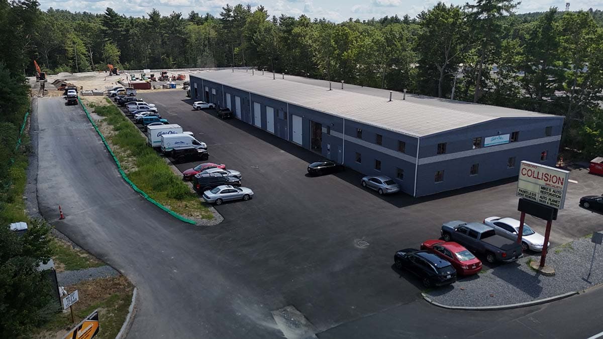 Aerial view of an industrial business park building with loading docks and parking, near Patriot Park in Foxborough, MA